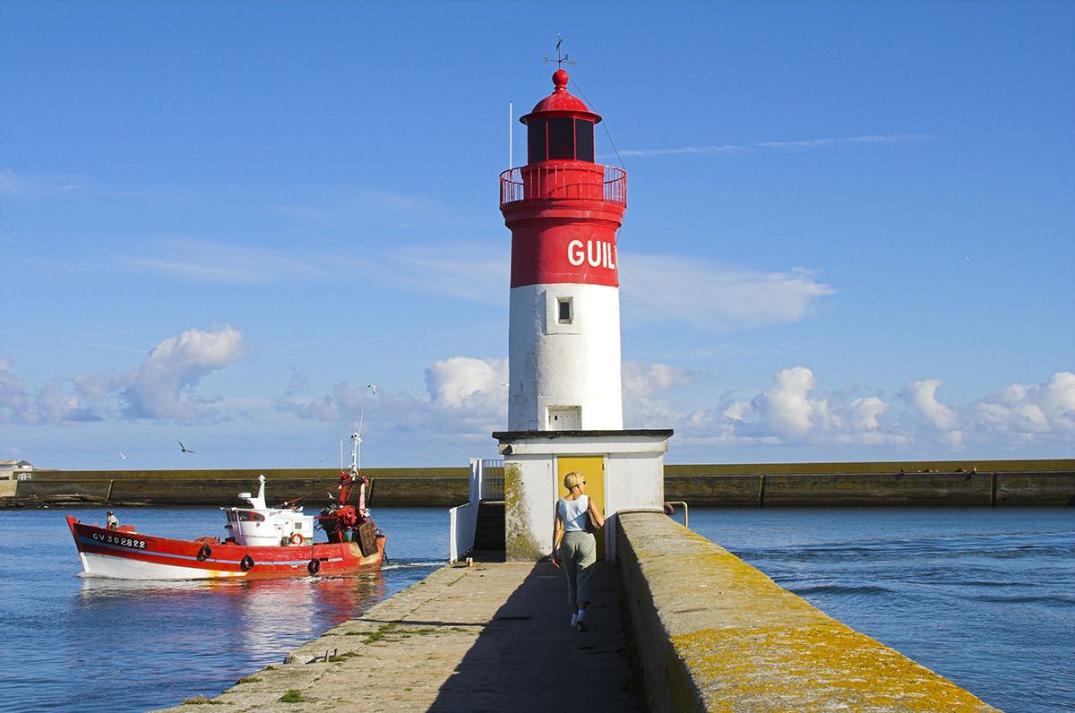 femme qui marche en direction du phare de Guilvinec