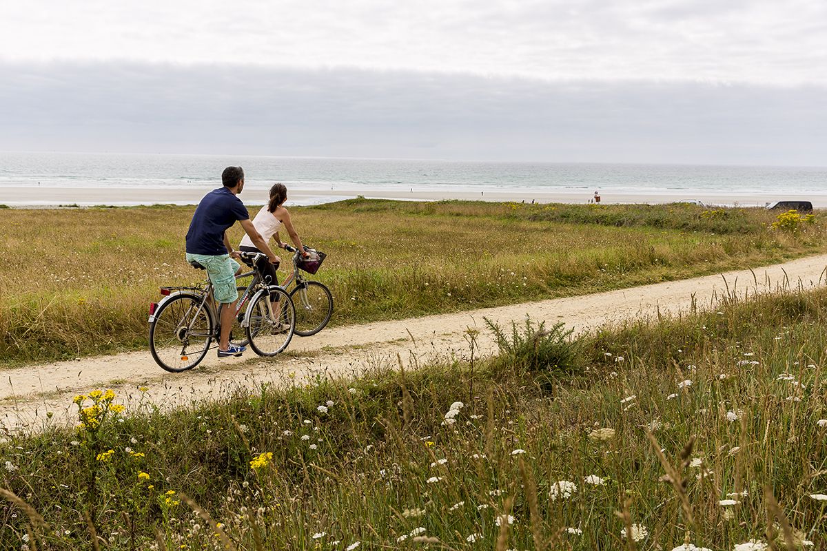 deux personnes se baladent en vélo sur la côte bretonne